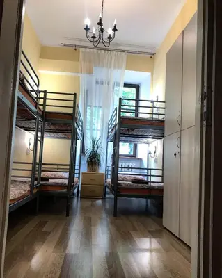 a room with three bunk beds and a chandelier at Hostel u Kmity in Kraków
