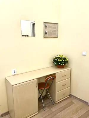 a desk in a room with a mirror and flowers at Hostel u Kmity in Kraków
