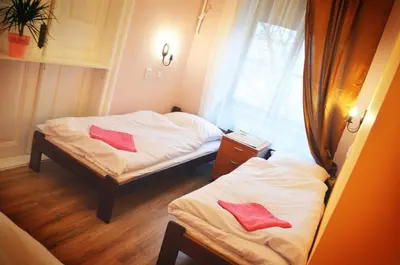 a small room with two beds and a window at Hostel u Kmity in Kraków