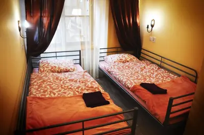 two beds sitting next to a window in a room at Hostel u Kmity in Kraków
