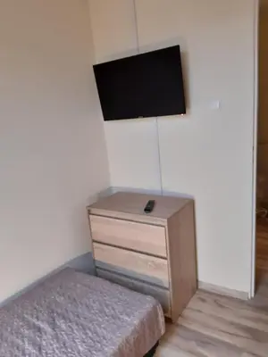 a bedroom with a bed and a tv on the wall at Apartamenty Nad Wisłą in Skawina