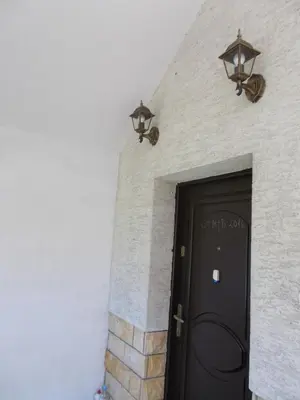 a black door with two lights on a brick wall at Apartamenty Nad Wisłą in Skawina