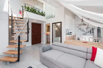 a living room with a couch and a staircase at Tomasza Residence in Kraków