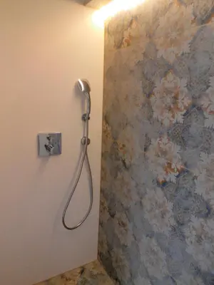 a shower in a bathroom with a floral wall at Tomasza Residence in Kraków