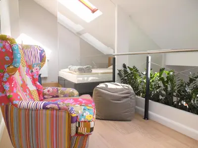a living room with a chair and a bed at Tomasza Residence in Kraków