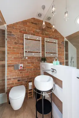 a bathroom with a white sink and a brick wall at Tomasza Residence in Kraków