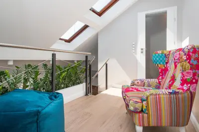 a living room with a chair and a staircase at Tomasza Residence in Kraków