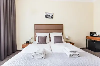 a bedroom with a large white bed with towels on it at Aparthotel Old Town in Kraków