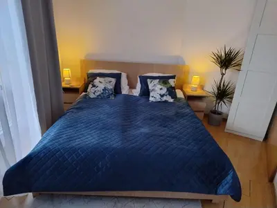 a bedroom with a blue bed with blue sheets and pillows at GreenApartament in Kraków