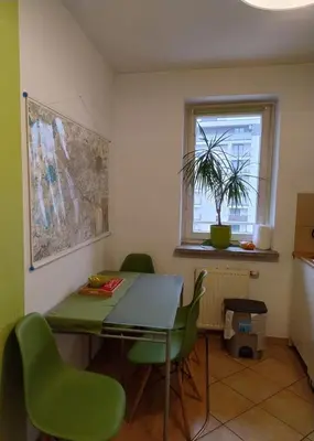 a dining room with a table and green chairs at GreenApartament in Kraków
