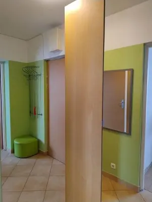 a room with green walls and a green ottoman at GreenApartament in Kraków
