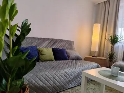a living room with a couch and a table at GreenApartament in Kraków