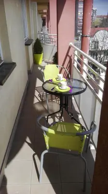 a table and chairs on the balcony of a building at GreenApartament in Kraków