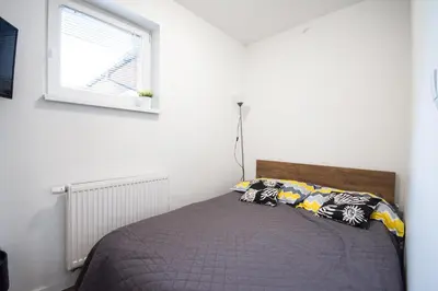 a bed in a white room with a window at Willa Kamilówka in Rabka