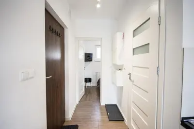 a hallway with white walls and a door and a floor at Willa Kamilówka in Rabka