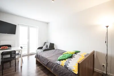 a bedroom with a bed and a table with a chair at Willa Kamilówka in Rabka