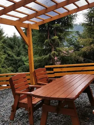 a wooden picnic table and two chairs under a pergola at Zawoja Chaty Górskie D1 in Zawoja