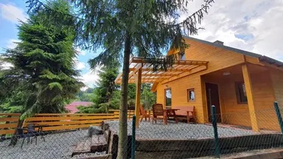 a house with a table and chairs in front of it at Zawoja Chaty Górskie D1 in Zawoja
