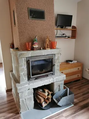 a living room with a stone fireplace at Zawoja Chaty Górskie D1 in Zawoja
