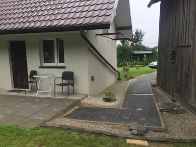 a patio with chairs and a table next to a house at Nasza Polana Pokoje Noclegi Pieskowa Skała Ojców in Pieskowa Skała