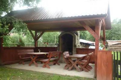 a wooden pavilion with a table and chairs under it at Zawoja Pod Grapą in Zawoja