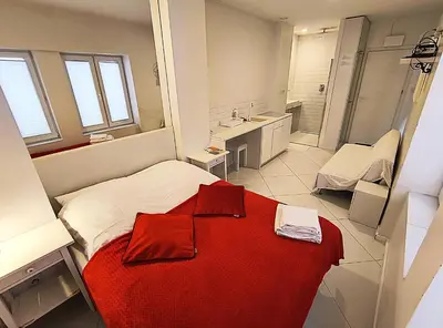 a bedroom with a red blanket on a bed at Mirror Apartments in Kraków