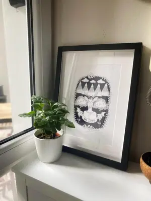 a picture frame sitting on a shelf next to a plant at Studio z ogrodem przy Starej Zajezdni in Kraków