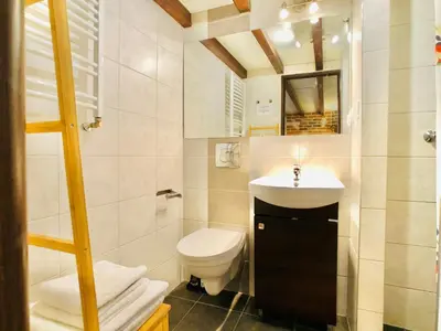 a small bathroom with a toilet and a sink at Studio z ogrodem przy Starej Zajezdni in Kraków