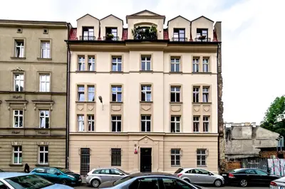 a large building with a balcony on top of it at Studio z ogrodem przy Starej Zajezdni in Kraków