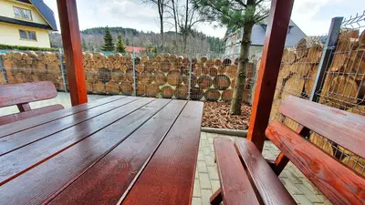 a wooden porch with two benches and a fence at Zawoja Chaty Górskie D3 in Zawoja