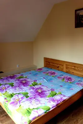a bedroom with a bed with a floral bedspread at Zawoja Chaty Górskie D3 in Zawoja