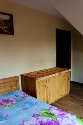 a bedroom with a wooden bed and a black door at Zawoja Chaty Górskie D3 in Zawoja