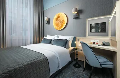 a living room with a couch and a table and a tv at Leonardo Boutique Hotel Krakow Old Town in Kraków