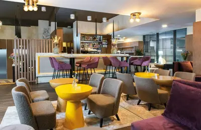 a bar with purple stools in a restaurant at Leonardo Boutique Hotel Krakow Old Town in Kraków