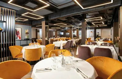 a dining room with tables and chairs in a restaurant at Leonardo Boutique Hotel Krakow Old Town in Kraków
