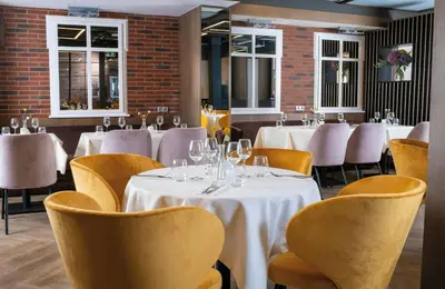 a restaurant with yellow chairs and tables and chairs at Leonardo Boutique Hotel Krakow Old Town in Kraków