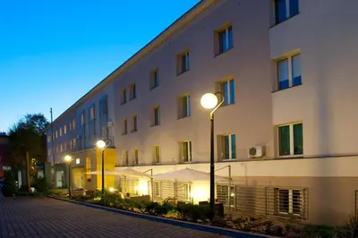 a large white building with street lights in front of it at Brojan in Jaworzno