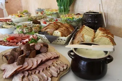 a buffet of food with meat and bread on a table at Gościniec pod Lubomirem in Węglówka