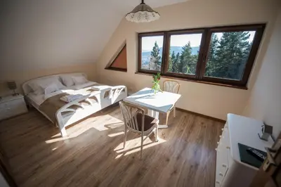 a bedroom with a bed and a desk and a table at Gościniec pod Lubomirem in Węglówka