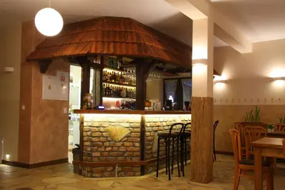 a bar in a restaurant with a stone wall at Gościniec pod Lubomirem in Węglówka