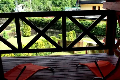 a view from a window of a patio with red chairs at Zawoja Chaty Górskie D5 in Zawoja