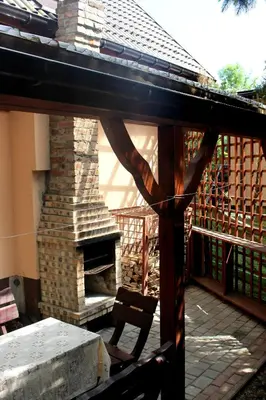 a patio with a stone fireplace and a table and chair at Zawoja Chaty Górskie D5 in Zawoja