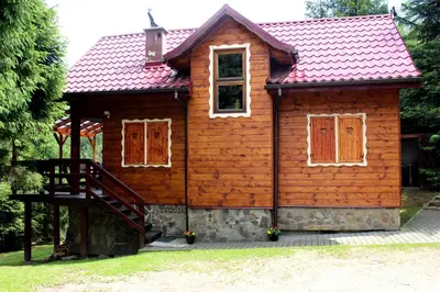 a small wooden house with a red roof at Zawoja Chaty Górskie D2 in Zawoja