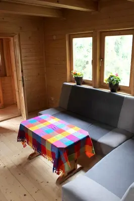 a room with a couch with a colorful blanket on it at Zawoja Chaty Górskie D2 in Zawoja