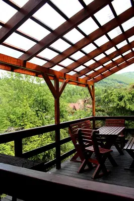 a wooden deck with a table and chairs on it at Zawoja Chaty Górskie D2 in Zawoja