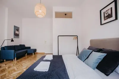 a bedroom with a bed and a blue couch at Michałowskiego 11 in Kraków