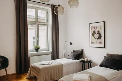 a bedroom with two beds and a window at Michałowskiego 11 in Kraków