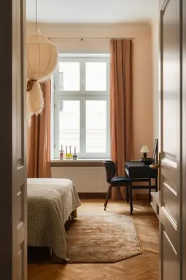 a bedroom with a bed and a desk and a window at Michałowskiego 11 in Kraków