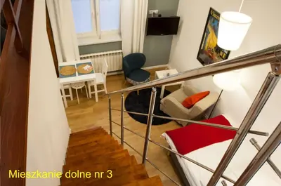 a room with a staircase and a living room at Rondo Mogilskie Apartment in Kraków