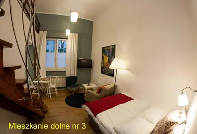 a hotel room with a bed and a staircase at Rondo Mogilskie Apartment in Kraków